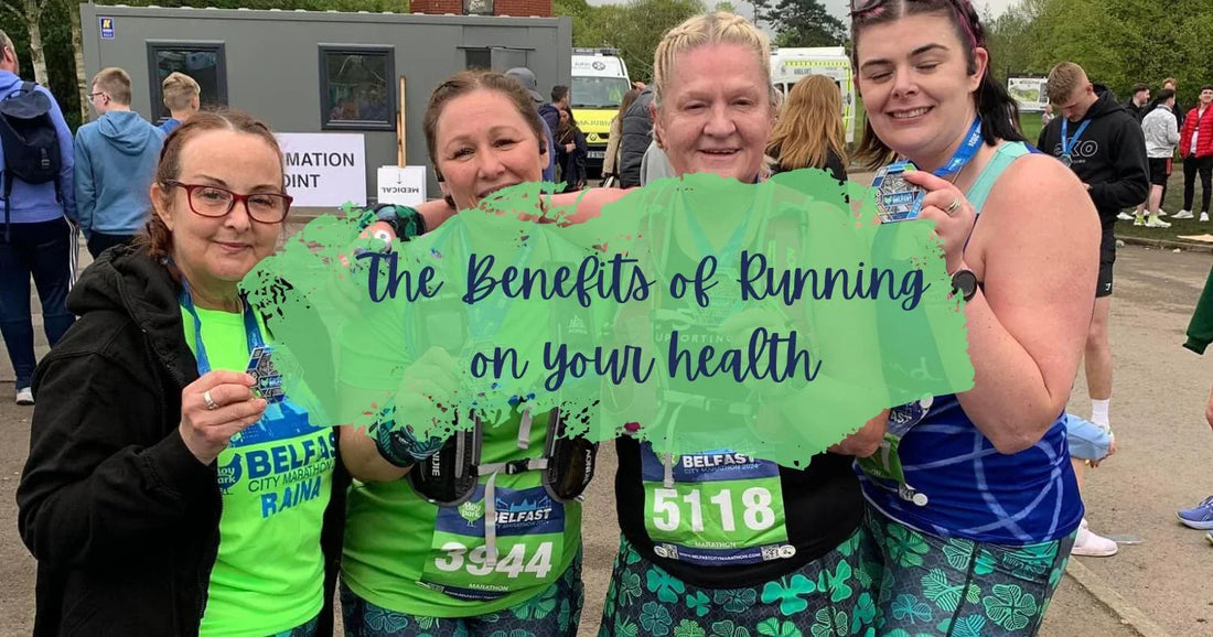 Four women runners smiling and holding medals at Belfast City Marathon event outdoors