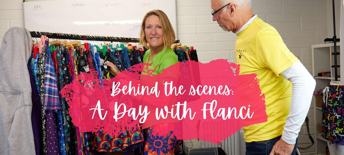 Woman and man sorting colorful Flanci clothing on hangers in bright workspace with whiteboard