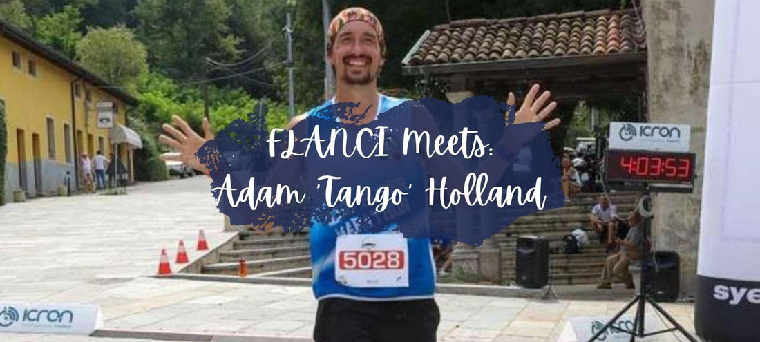 Smiling male runner wearing blue race bib 5028 finishing race with time 4:03:53 in outdoor village setting