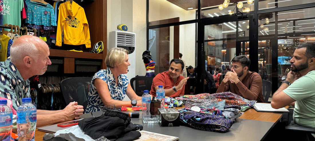 Group of diverse people discussing colorful sportswear fabrics in office meeting room
