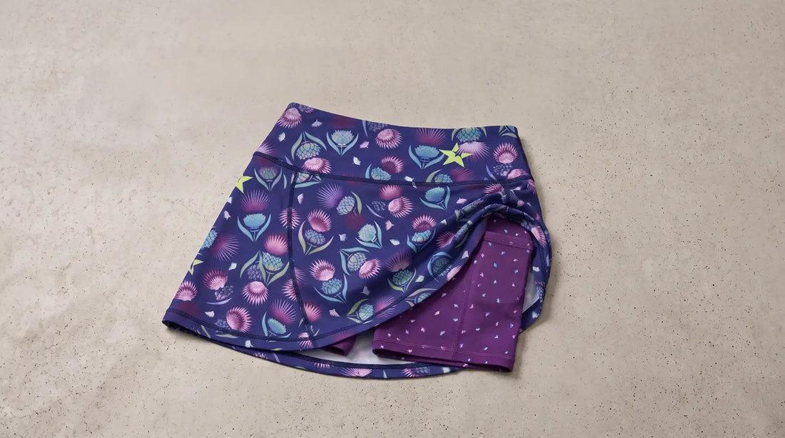 Purple thistle-patterned athletic skort with built-in shorts.
